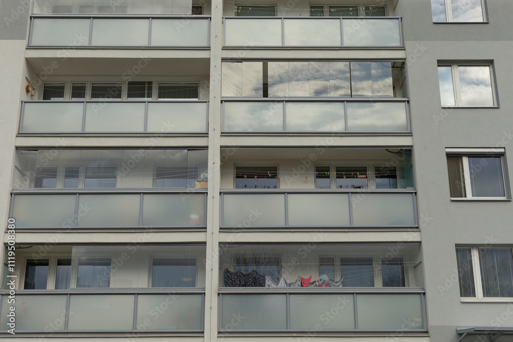 A modern apartment building featuring attractive balconies and large windows A modern apartment building featuring attractive balconies and large windows