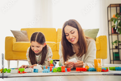 Mother and daughter bonding over a fun building activity in the living room