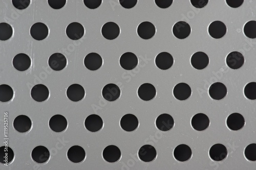 Perforations in a grey metal panel