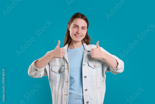 Happy woman showing thumbs up on light blue background. Like gesture