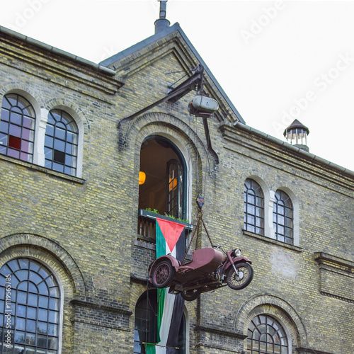 Old motorcycle attached to an old building as an installation.