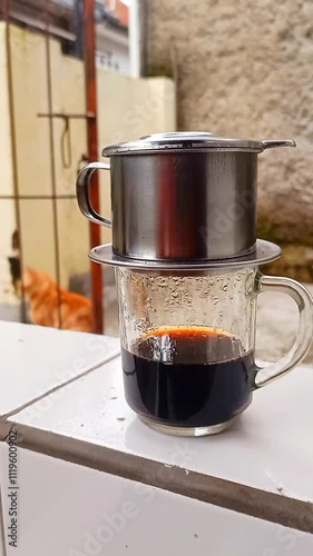 The barista serves coffee with a Vietnam drip coffee maker. Vietnam drip coffee