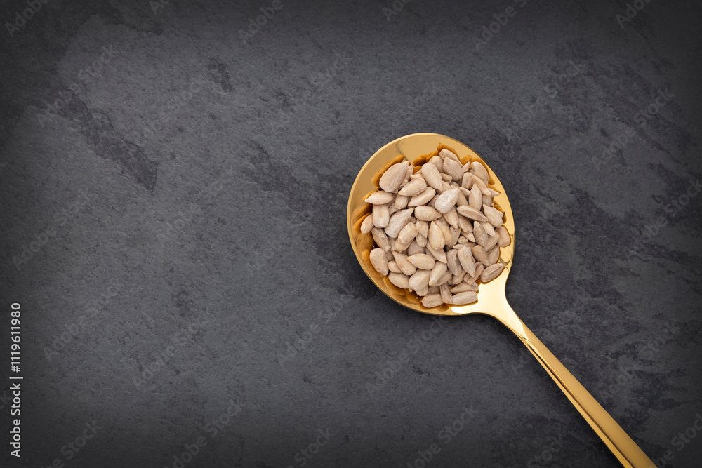 Fototapeta premium Helianthus annuus - Raw and dried sunflower seeds in a spoon.