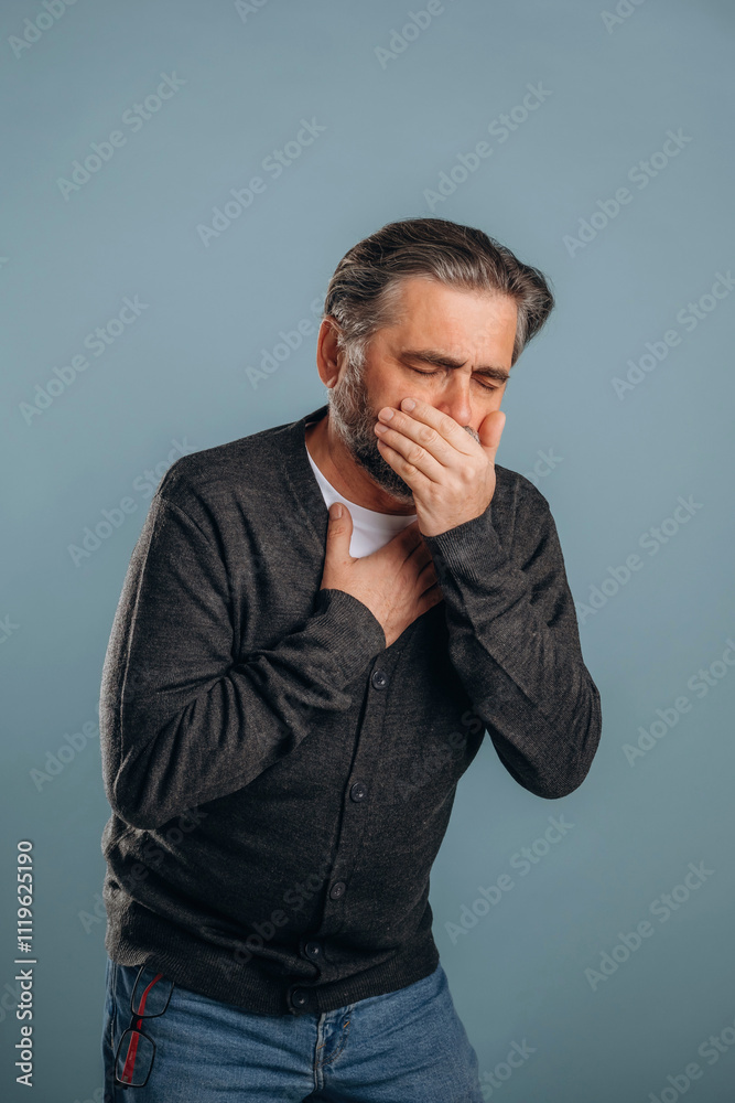 Ill, sick, having pain in the chest. Senior man is standing in the studio against background Ill, sick, having pain in the chest. Senior man is standing in the studio against background