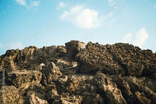 Background of rocky slope and blue sky. Old stones on mountain top.