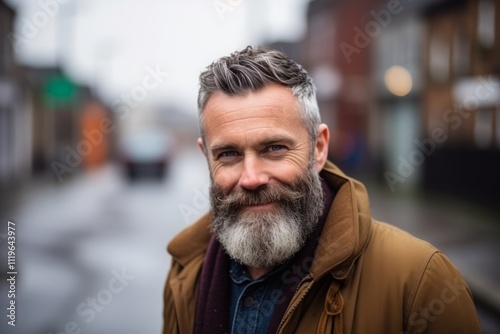 Portrait of a handsome man with long gray beard and mustache in the city