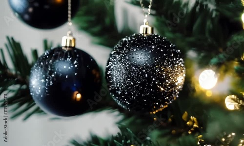 Close-up of elegant black Christmas ornaments with sparkling glitter details, hanging gracefully on green Christmas tree. modern, luxurious holiday decor. fashion-oriented festive, premium, elegant