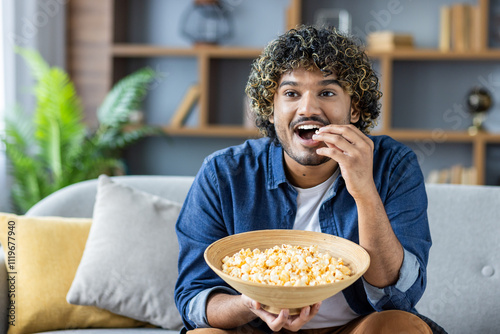Konstfotografi Young man savoring popcorn, enjoying leisure time at home