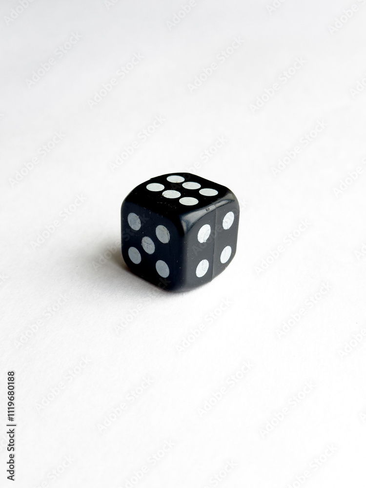 Black six sided dice on white surface with five dots Black six sided dice on white surface with five dots
