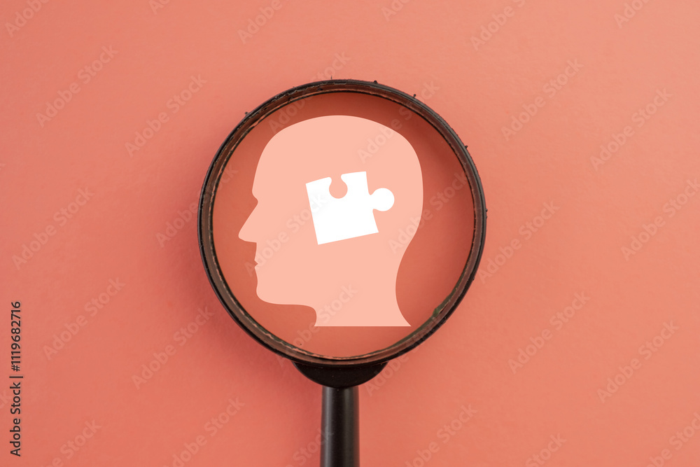 White puzzle piece within a human head under magnifying glass concept ...