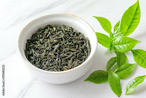 Loose Leaf Tea in White Bowl with Fresh Green Leaves. Ideal for concepts related to tea, health, and organic lifestyles. photo