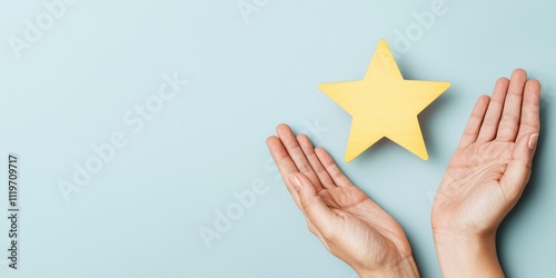 Two hands gently hold a yellow star against a light blue background, symbolizing hope and aspiration.