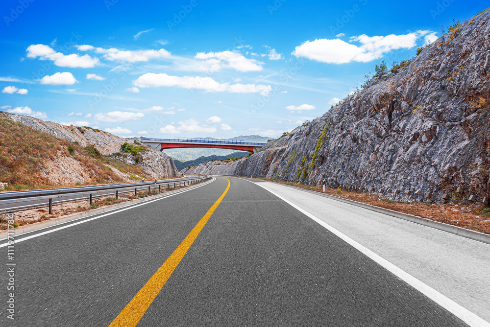 Transport bridge crossing a suburban highway in a beautiful mountainous area.