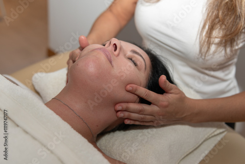 professional, applies a facial massage to a client