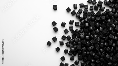 Black polymer pellets scattered on a clean white background for industrial or manufacturing applications in plastics and materials science
