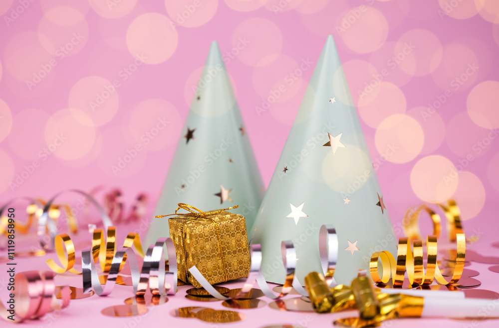Obraz premium Party hats, confetti and decorations for party on pink background. Copy space. Close-up.