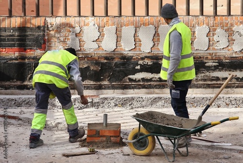 Fotografie Dos obreros de la construcción trabajando en un obra de un edificio en Madrid eq