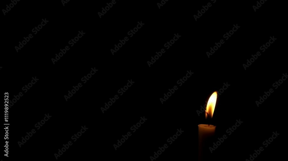 Close up of candle flame swaying in the wind isolated on black background.The candle flame is almost extinguished.The concept of hope and spirit.Copy space for text.Real time raw video no edit