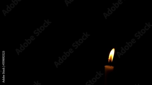 Close up of candle flame swaying in the wind isolated on black background.The candle flame is almost extinguished.The concept of hope and spirit.Copy space for text.Real time raw video no edit