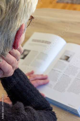 Woman seen from behind reading in a book