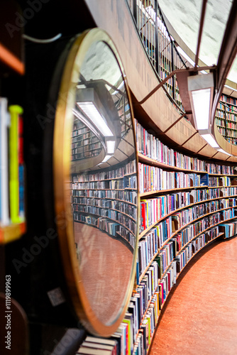 Curved Library Bookshelves Reflecting in Round Mirror with Modern Lighting in Spacious Interior, Featuring Numerous Colorful Books, Creating an Inviting Atmosphere for Studying and Reading Enthusiasts