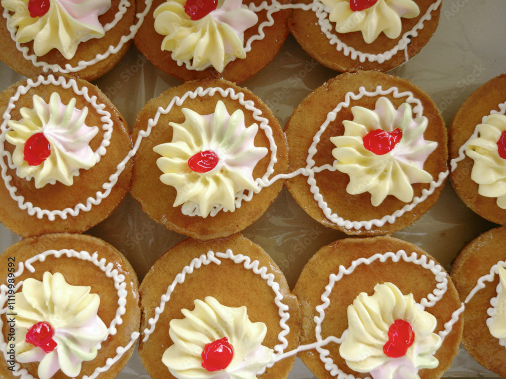 Mini cakes coated with caramel and piped with whipped cream. Mini cakes coated with caramel and piped with whipped cream.