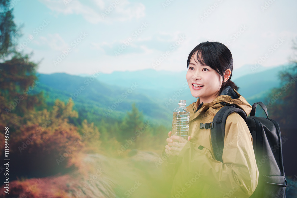 登山をしながら水分補給をする若い女性 登山をしながら水分補給をする若い女性