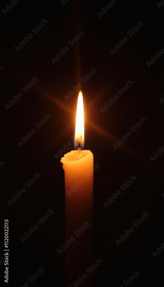 Single lit memory candle glowing brightly against a dark background Single lit memory candle glowing brightly against a dark background