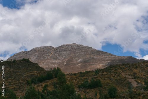 Rocky mountain in the Peruvian puna surrounded by nature on a sunny but cloudy summer day