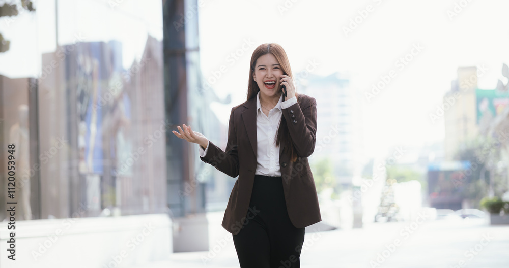 A casually dressed Asian businesswoman sips coffee while playing with her mobile phone outdoors. She smiles confidently and represents the new generation of entrepreneurs. A casually dressed Asian businesswoman sips coffee while playing with her mobile phone outdoors. She smiles confidently and represents the new generation of entrepreneurs.