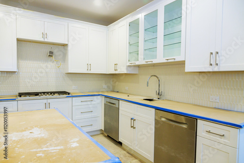 Fotografía Newly remodeled kitchen features white cabinets, stainless steel appliances, an unfinished countertop