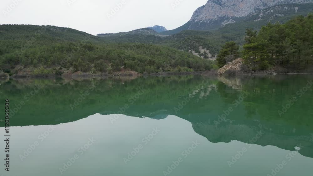 Calm lake reflecting mountain scenery in serene natural landscape Calm lake reflecting mountain scenery in serene natural landscape