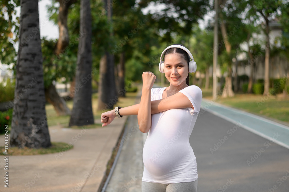 Beautiful pregnant woman stretching and exercising in the park Beautiful pregnant woman stretching and exercising in the park