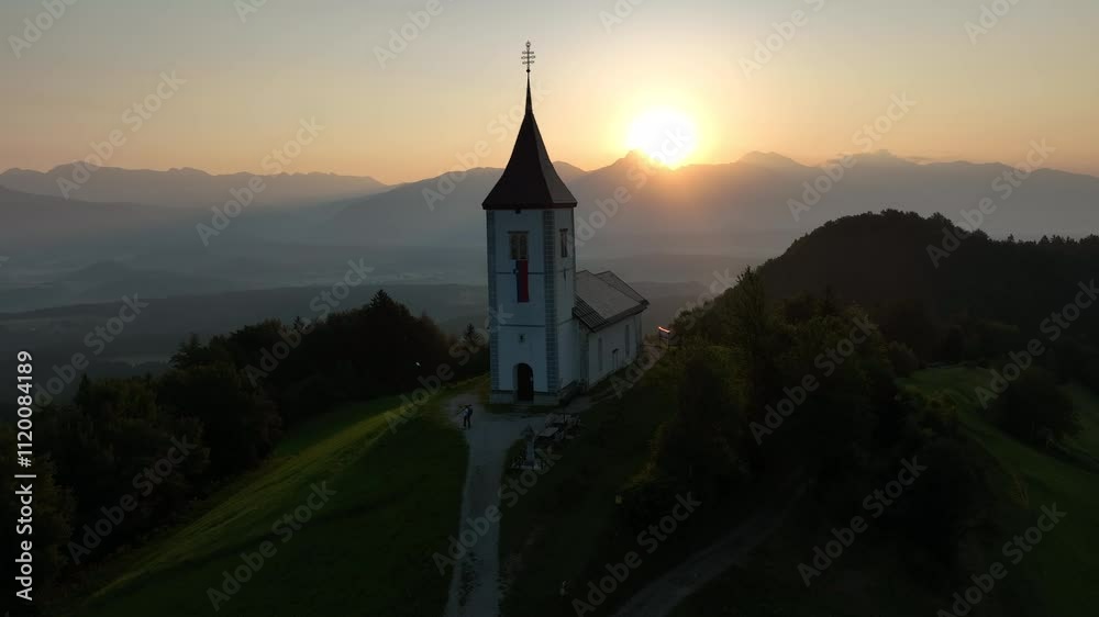 Drone shot of the Catholic church of Saint Primus and Felician with a green landscape of hills Drone shot of the Catholic church of Saint Primus and Felician with a green landscape of hills