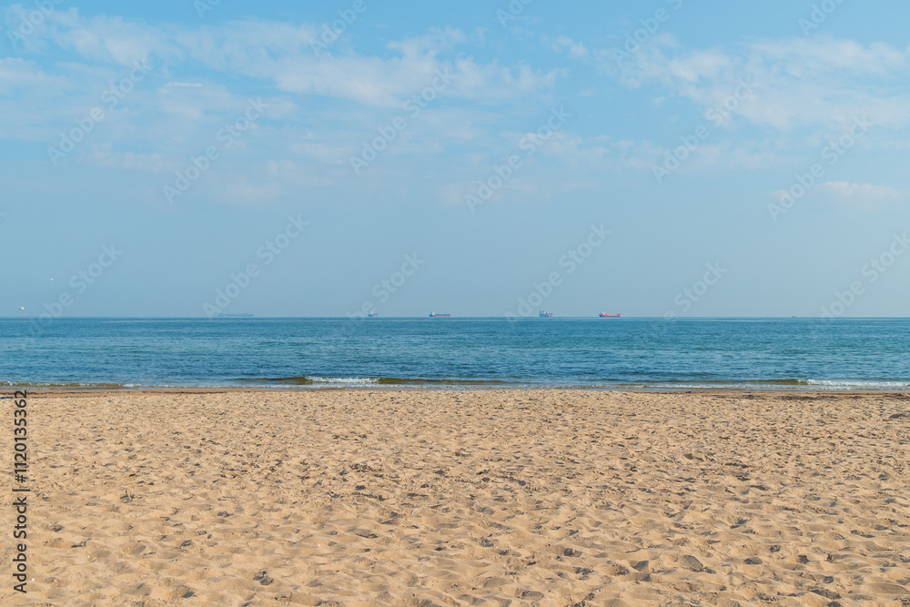 Sandy beach, blue sea and blue sky on a sunny day. Simple seascape. Sandy beach, blue sea and blue sky on a sunny day. Simple seascape.