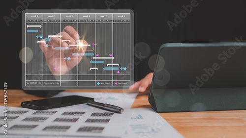 Focused individual analyzes Gantt chart displaying project timelines, task progress over six weeks visual tool aids in effective project management and time allocation photo