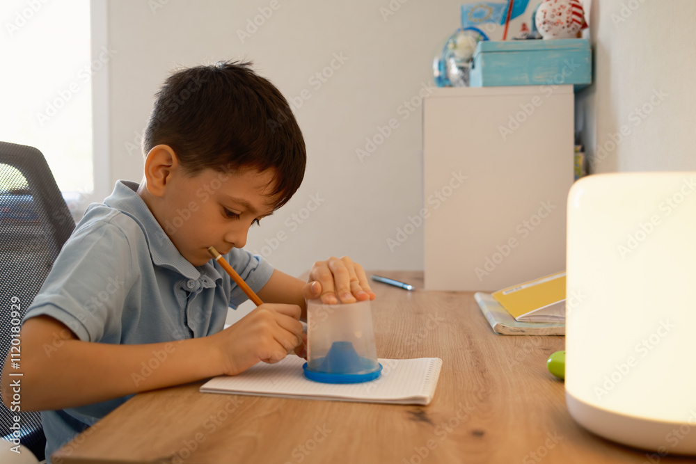 A young boy is deeply immersed in his homework, working diligently with a pencil at his desk in a cozy study environment. A calm and focused atmosphere is evident in the image. A young boy is deeply immersed in his homework, working diligently with a pencil at his desk in a cozy study environment. A calm and focused atmosphere is evident in the image.