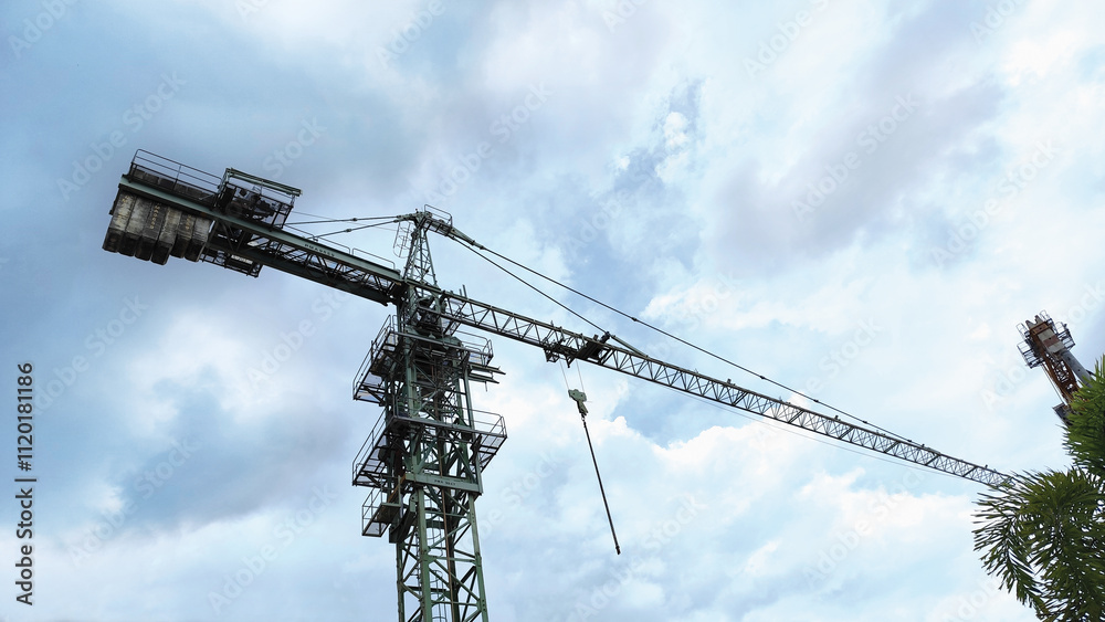 low angle view of a construction tower crane against blue sky. building construction low angle view of a construction tower crane against blue sky. building construction