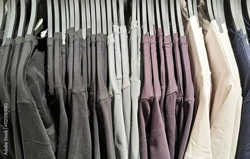 Row of shirts hanging on hangers in a clothing store. Fashion retail background. Display of casual t-shirts in a boutique. Shopping for apparel. Textile and fabric wardrobe selection. photo