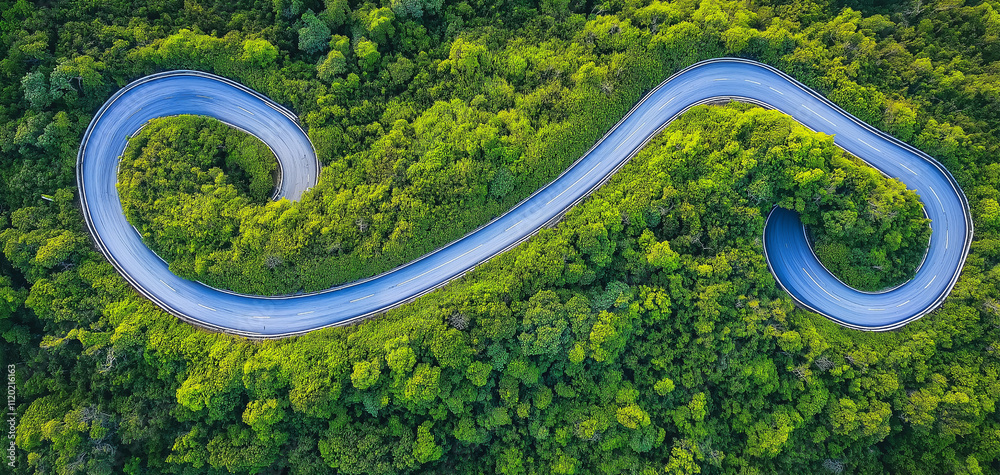 Stunning aerial view of a road surrounded by green trees Stunning aerial view of a road surrounded by green trees