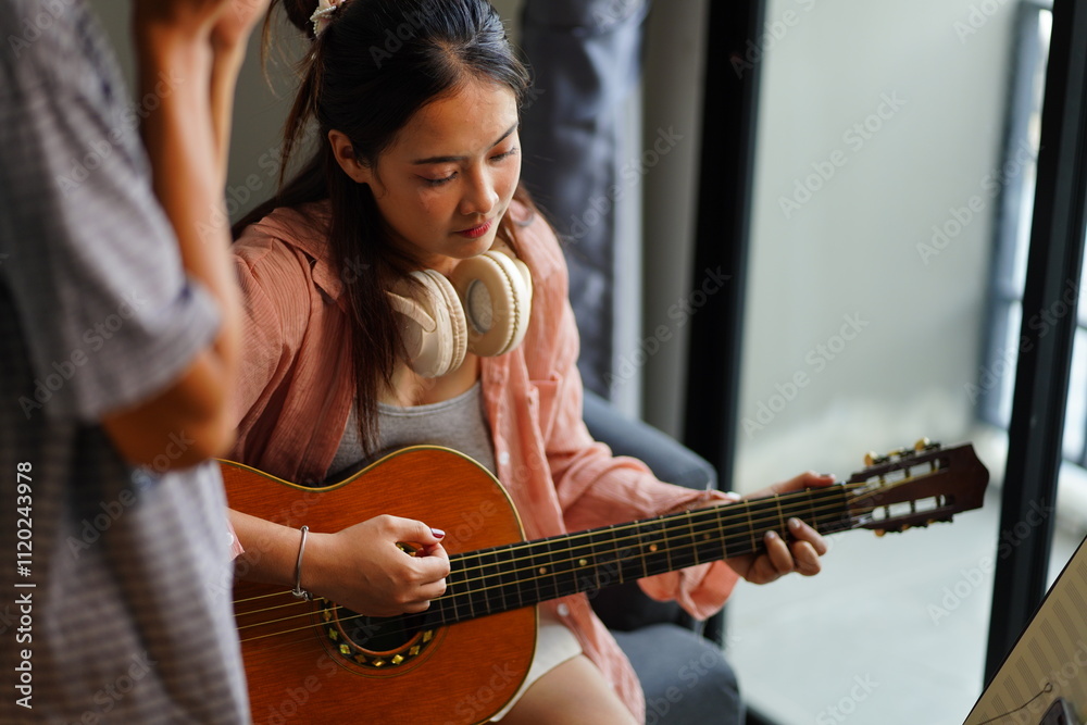 Fototapeta premium Working Asians are learning international musical skills at home