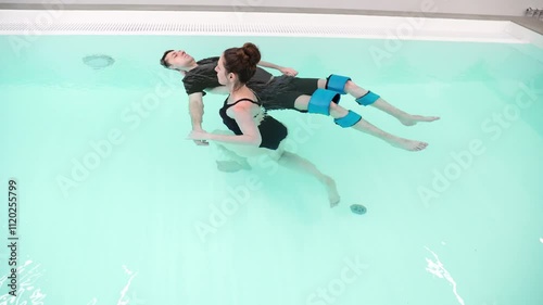 Aquatic therapy in motion guided floating and relaxation techniques for wellness and rehabilitation in a tranquil pool setting.