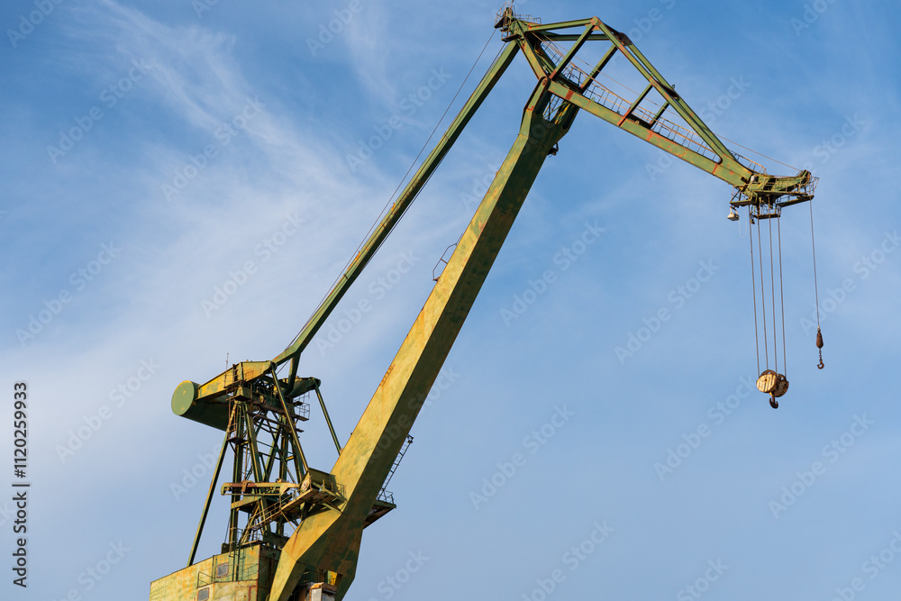 Large green crane protruding into the sea. Blue sky background Large green crane protruding into the sea. Blue sky background