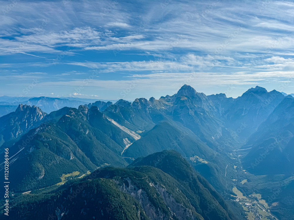 Fototapeta premium Aerial view of Upper Soca Valley surrounded by majestic mountain peaks of Western Julian Alps. On top of Cima Del Lago on border Italy Slovenia, Triglav National Park. Wanderlust in alpine wilderness