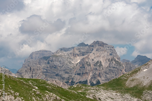 Panoramic view of cloud covered rocky rugged mountain peak of Monte Fibion in majestic Brenta Dolomites, Trentino, Italy. Wanderlust in alpine wilderness. Hiking in pristine Italian Alps in summer photo