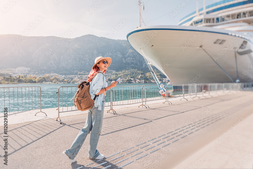 Tourist with backpack walking near cruise ship at harbor in sunny summer day