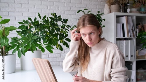 young Caucasian woman wearing home clothes applying makeup at home in the morning , morning routine