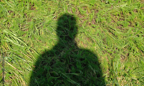 Schatten von einer unbekannten Person in einem Garten. Schattenbild von einem unbekannten nicht identifizierbaren Mann. Menschliches Schattenbild., Phantombild