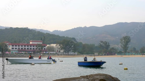Two boats floating in the water at the Hong kong harbour in fog daytime