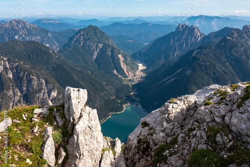 On top of Cima Del Lago with aerial view of alpine lake Lago Del Predil in Val Canale surrounded by majestic mountain peaks of Western Julian Alps, Friuli Venezia Giulia, Italy. Wanderlust in nature photo